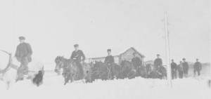Snøplogkjøring på Aune 24. februar 1913 med fem ridende karer foran snøplogen.