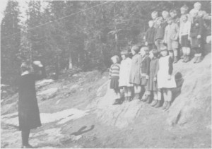 Lærer Ingeborg Aas dirigerer småskolebarnas sang ved Gresli gamle skole i 1932.
