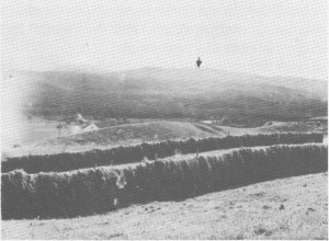 Leif Stuedal tok dette bildet i 1933, og han mente at ruiner på toppen av Gråsida (der pilen peker), stamma fra ei vardehytte. Mer sikkert er det at det har vært holdt vardevakt på Vektarhaugen (til venstre utafor bildet). Bak hesjene vises jordvollen på Stugudal skanse.