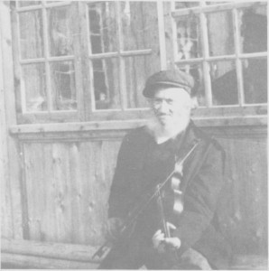 Ole Olsen Aune (1834—1927), til vanlig kalt Spellmann-Ola, utafor huset sitt i Olagarden ea. 1900.