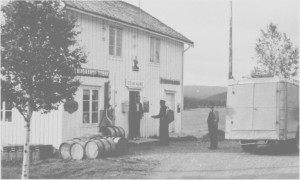 Odin Aune bygde opp en liten landhandel på Aune, og hadde dessuten stillinga som poståpner. Bildet er fra 1936, og Odin Aune tar her imot posten av sjåfør Sivert Eidem, Selburuta. Olaus Aune følger med.