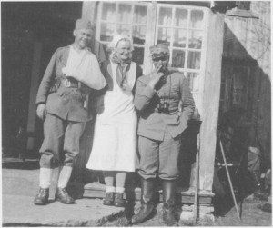 5. mai 1940 i Olagarden på Aune. Paula Høylo mellom to norkse krigere. (Bilde fra Odd Rygg: Kampene ved Garberg bru.)